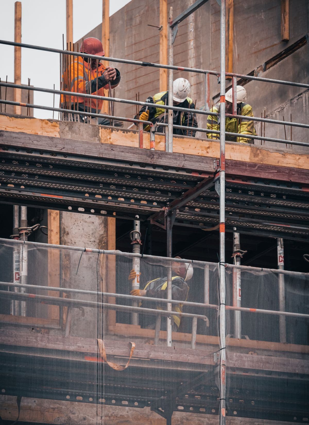 Construction workers engaged in building tasks on a scaffold