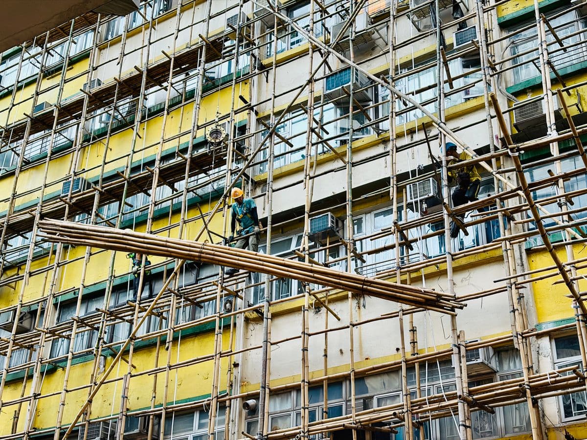 Builders working on scaffolding on a colorful building exterior
