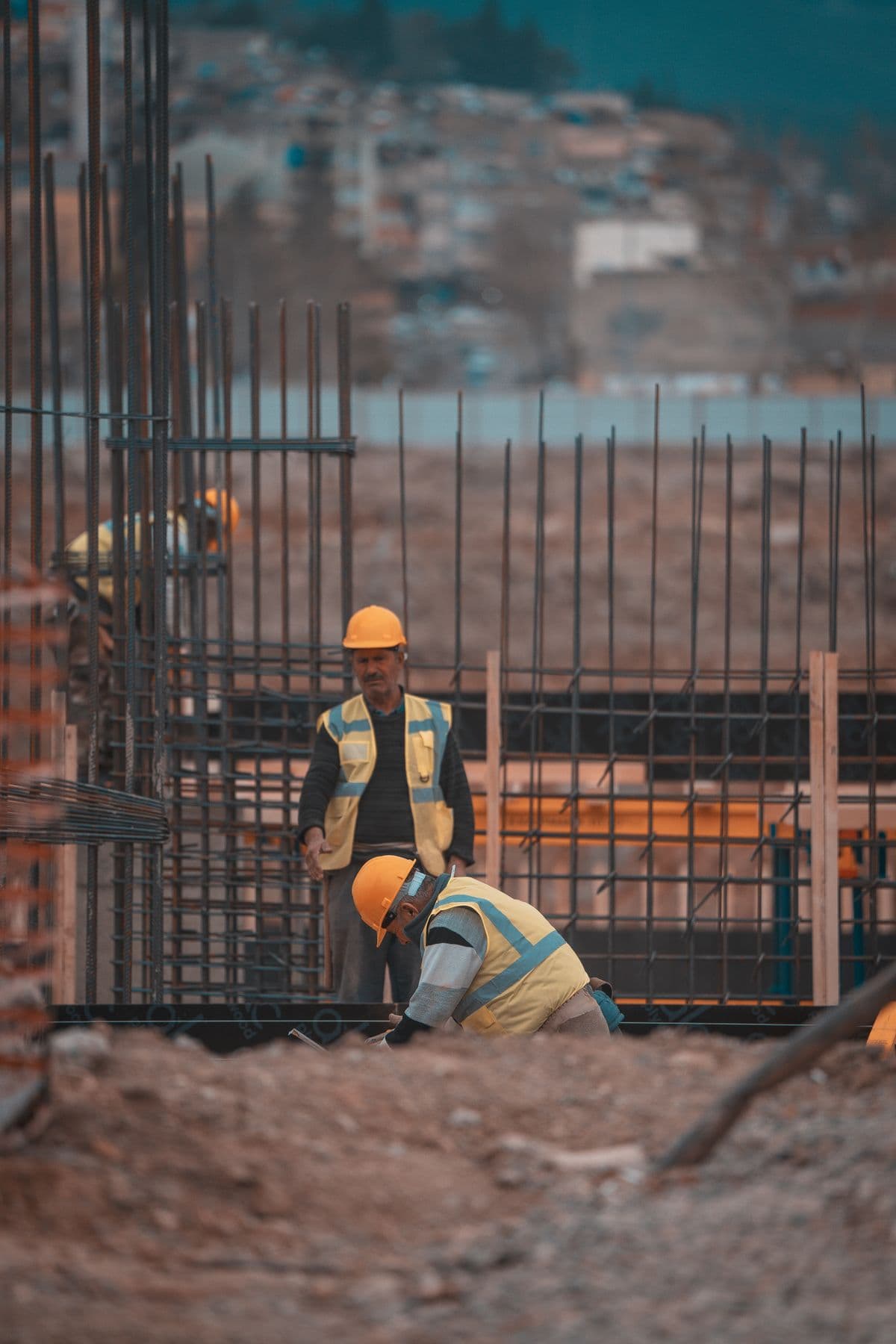 Construction workers on site adding steel reinforcement bars