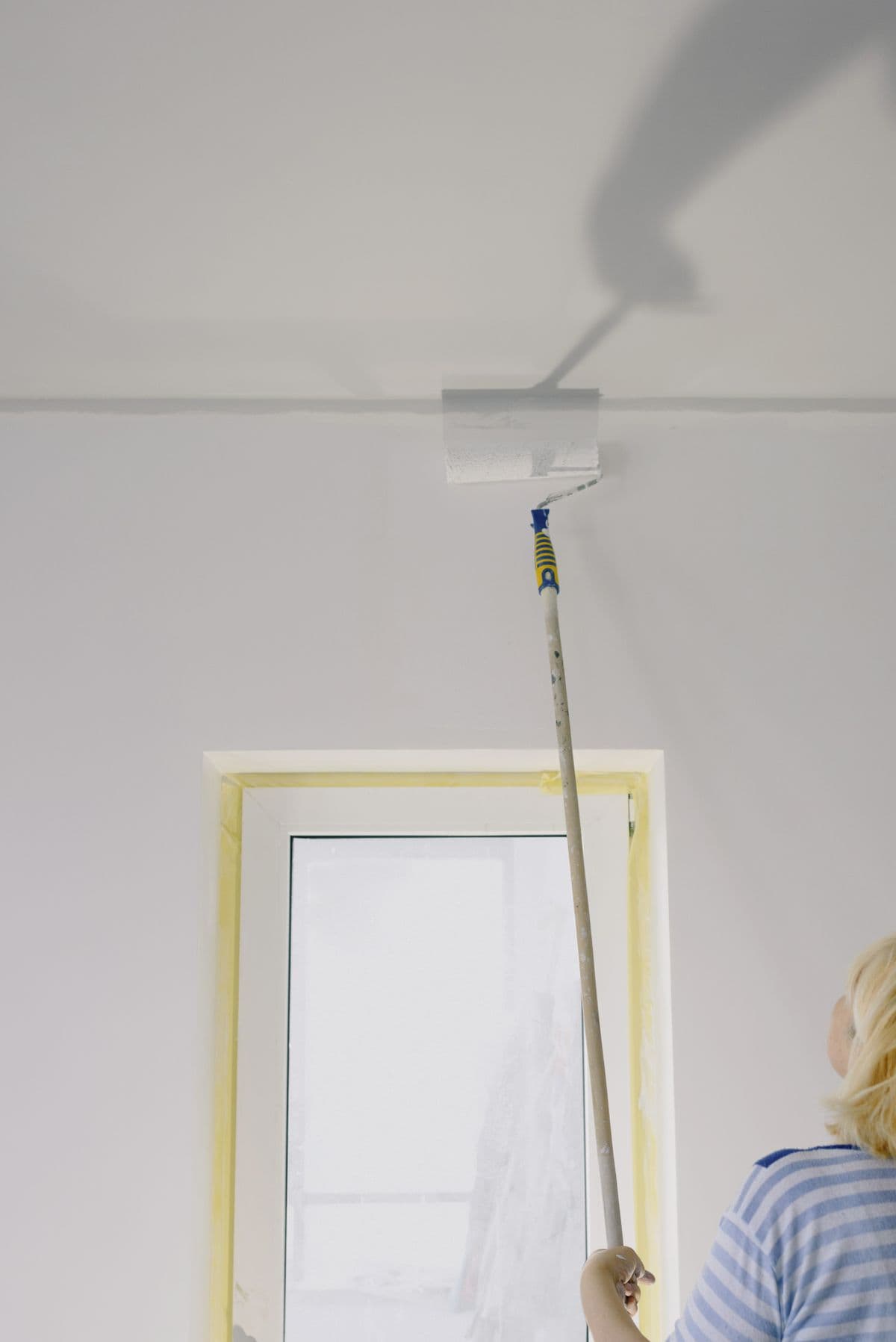 Painter holding a roller while renovating an interior wall