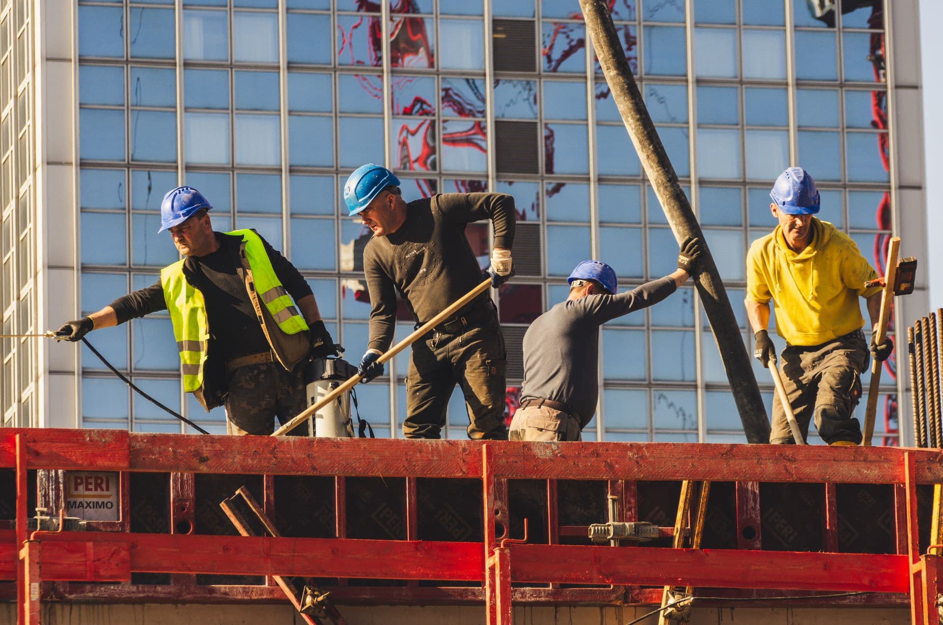 Construction workers in safety gear working on a high-rise building site