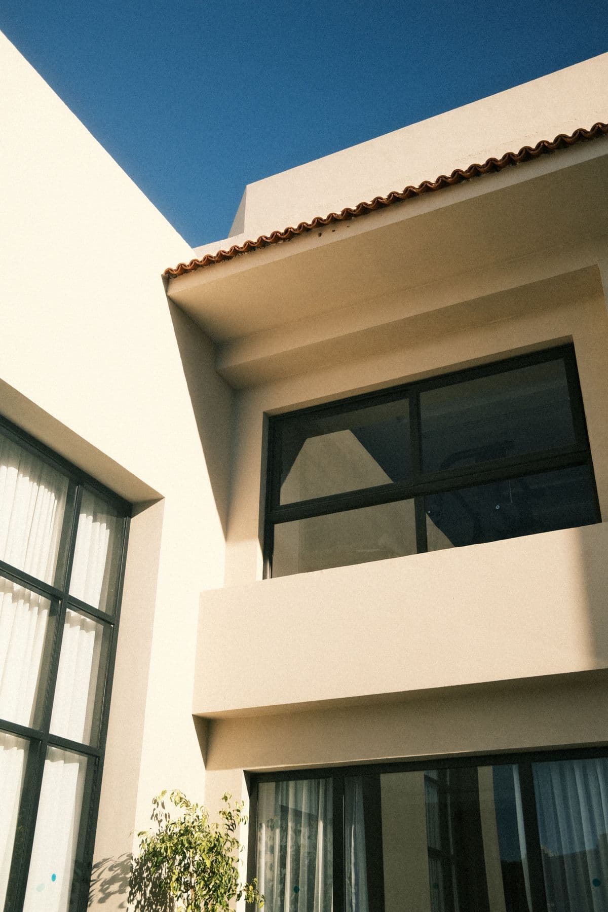 Elegant modern house exterior with large windows under a clear blue sky