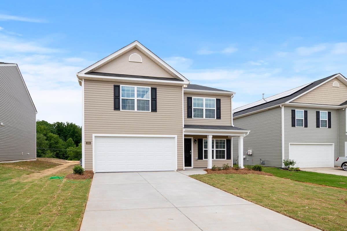 Contemporary two-story suburban home with a spacious driveway and lawn