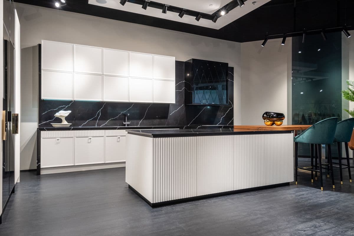 Sleek kitchen design featuring white cabinets, black countertops, and a central island
