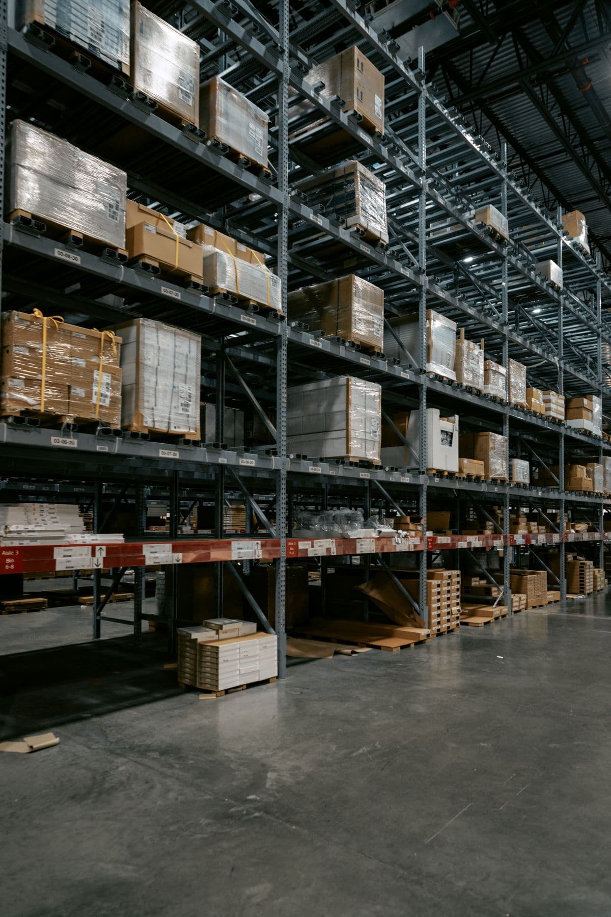 Well-organized industrial warehouse with stacked shelves and pallets for materials storage